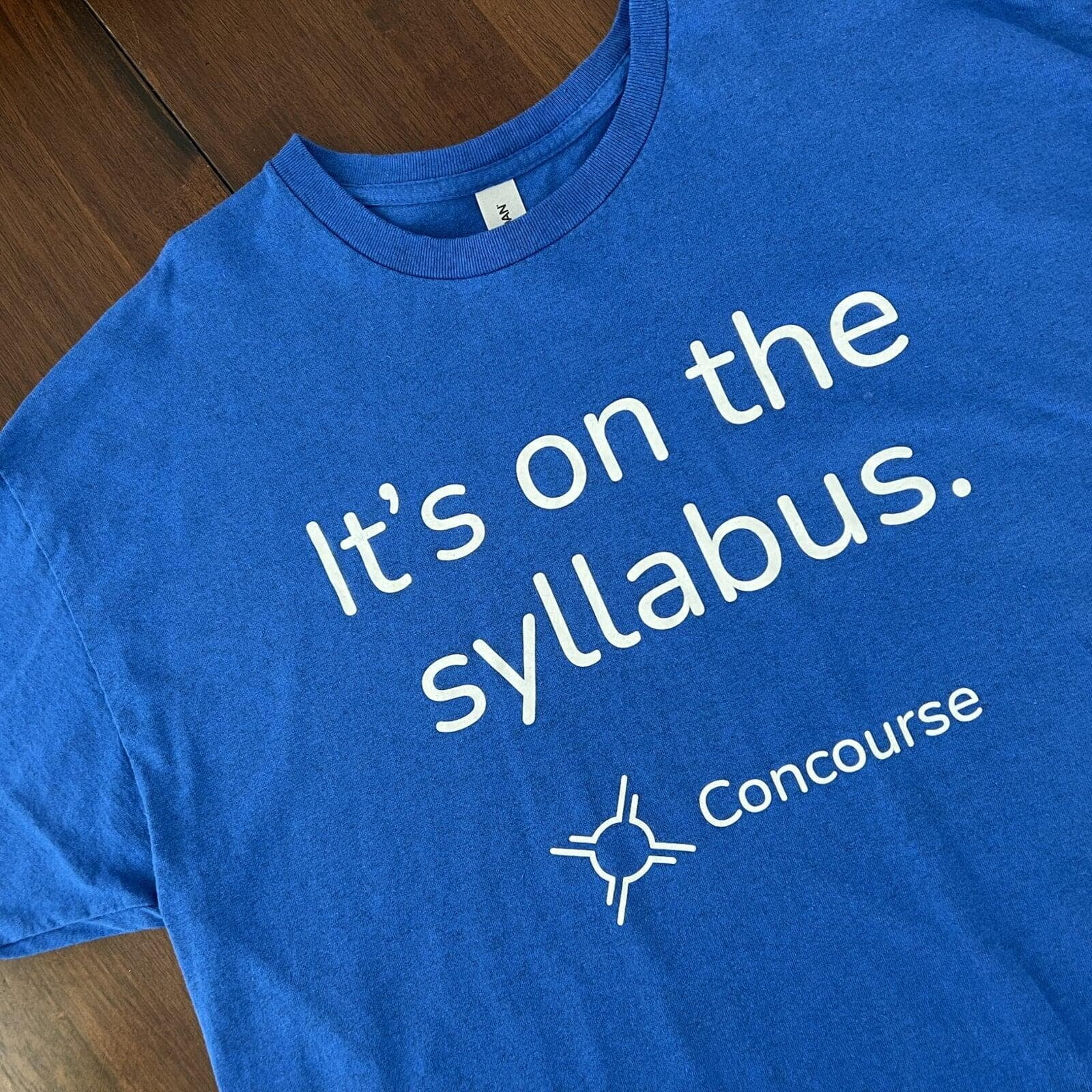 Blue t-shirt that says &quot;it's on the syllabus&quot; with the Concourse logo
