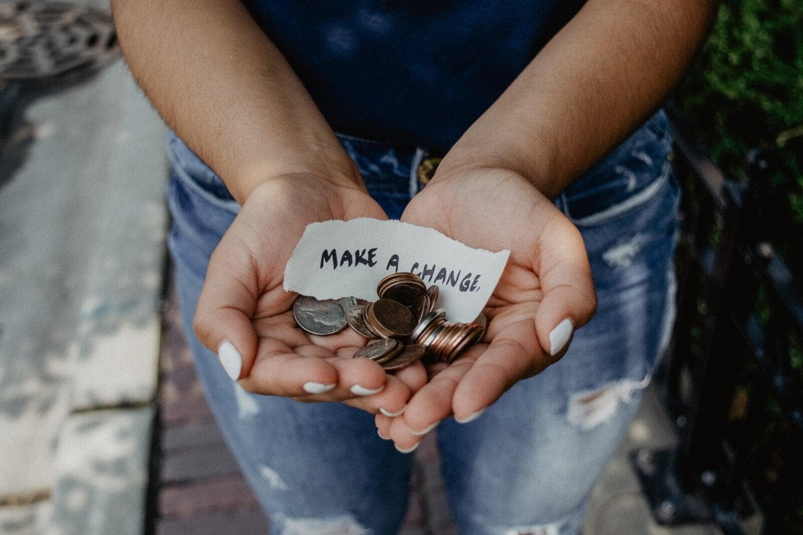 Person holding change and a piece of paper that says &quot;make a change&quot;